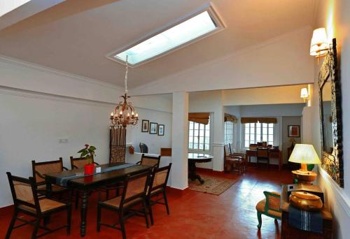 a dining room and living room with a table and chairs at Chhota Haazri, By The Rajbari Bawali in Darjeeling