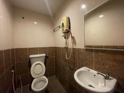 a bathroom with a toilet and a sink and a phone at HOTEL SAHARA INN BATU CAVES in Batu Caves