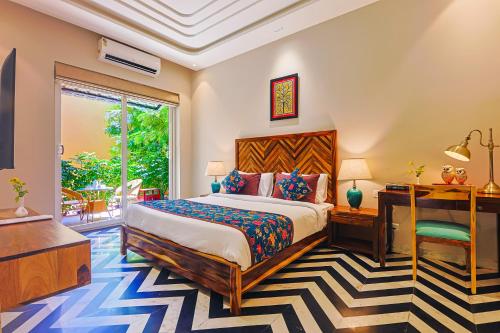 a bedroom with a bed and a desk at Ananyamaya nature lodge in Khilchipur