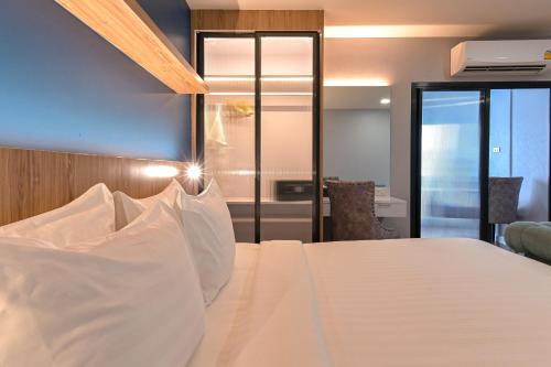 a bedroom with a bed with white pillows at Shewin de Bangkok in Ban Bang Bamru