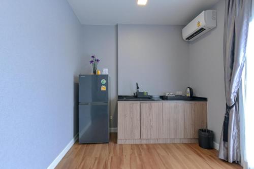 a kitchen with a refrigerator in the corner of a room at Shewin de Bangkok in Ban Bang Bamru
