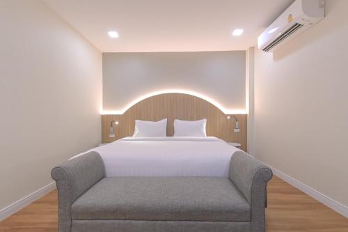 a bedroom with a bed and a chair at Shewin de Bangkok in Ban Bang Bamru
