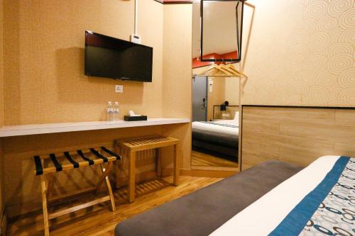 a hotel room with a bed and a tv at Golden Roof Hotel, Seri Iskandar in Seri Iskandar