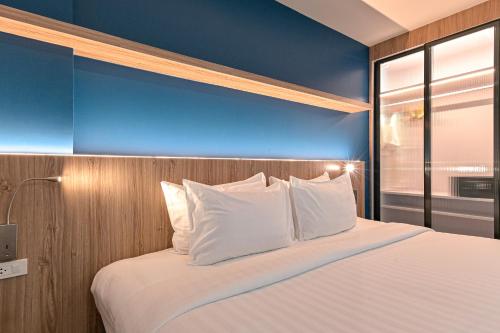 a bedroom with a large bed with white pillows at Shewin de Bangkok in Ban Bang Bamru