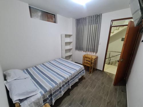 1 dormitorio con cama, mesa y espejo en LIRI House en Oxapampa