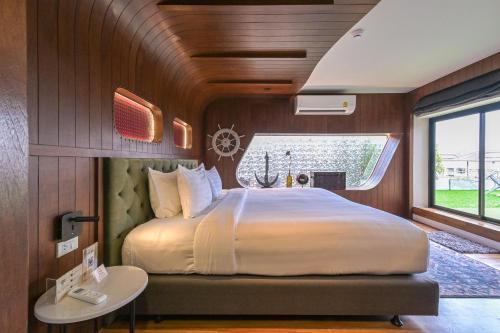 a bedroom with a large bed and a window at Shewin de Bangkok in Ban Bang Bamru