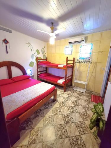 a bedroom with two bunk beds and a tiled floor at Jurema Hostel in Itacaré