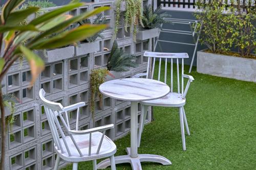 two chairs and a table and two chairs on the grass at Shewin de Bangkok in Ban Bang Bamru