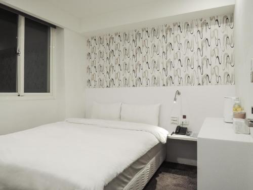 a white bedroom with a bed and a window at CHECK inn Express Taipei Yongkang in Taipei