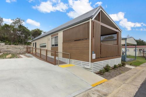 a small building with a ramp next to a parking lot at Reflections Bermagui - Holiday Park in Bermagui