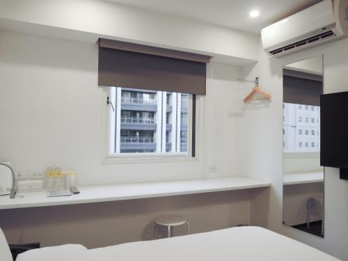 Habitación con ventana, cama y lavamanos en CHECK inn Express Taipei Yongkang en Taipéi