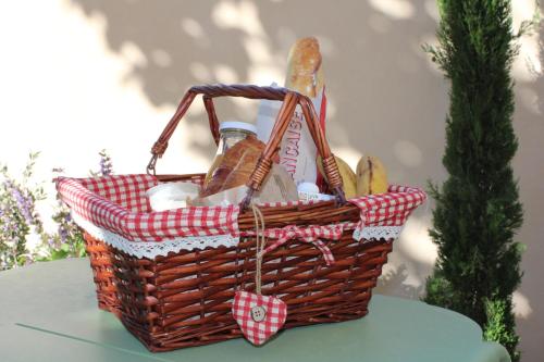 un panier rempli de nourriture et de pain sur une table dans l'établissement Château du Parc - Gîtes & spas à Pézenas, à Pézenas