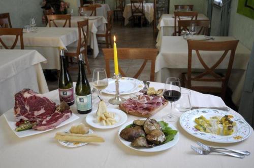 uma mesa com pratos de comida e garrafas de vinho em Il Rampicante-Monticelli Terme em Monticelli Terme