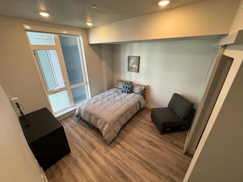 een slaapkamer met een bed, een stoel en een raam bij Luxury 1 Bedroom Apartment Near DownTown Oakland in Oakland