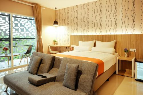 a hotel room with a bed and a couch at Front One Hotel Sragen in Sragen