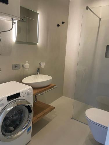 a bathroom with a washing machine and a sink at Family village apartment in Vrh