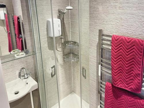 La salle de bains est pourvue d'une douche et d'un lavabo. dans l'établissement Greenway, à Ollerton