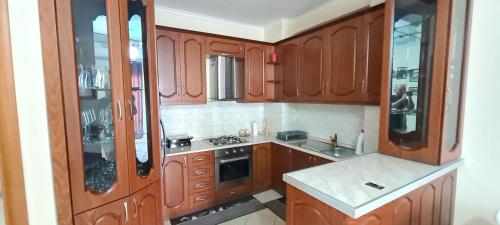 uma cozinha com armários de madeira e um forno com placa de fogão em Erin Apartments em Vlorë
