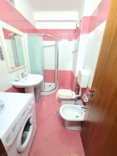 uma casa de banho rosa com 2 WC e um lavatório em Erin Apartments em Vlorë