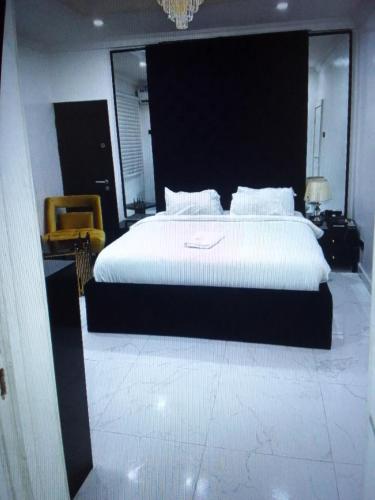 1 dormitorio con 1 cama blanca grande y 1 silla en Light house hotel and apartments Lekki phase 1, en Lekki