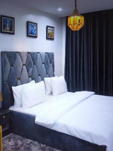 1 dormitorio con 1 cama blanca grande y cabecero negro en Light house hotel and apartments Lekki phase 1, en Lekki