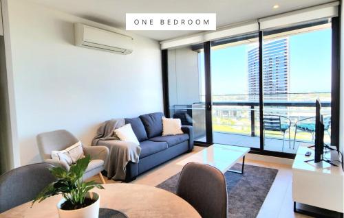 a living room with a couch and a table at Melbourne Lifestyle Apartments - Best Views on Collins in Melbourne