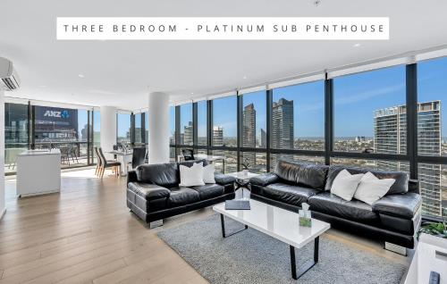 メルボルンにあるMelbourne Lifestyle Apartments – Best Views on Collinsのリビングルーム(ソファ、テーブル付)