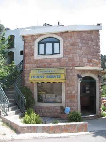 a brick building with a trust services sign on it at Apartments and Rooms Levantin Inn in Sveti Stefan