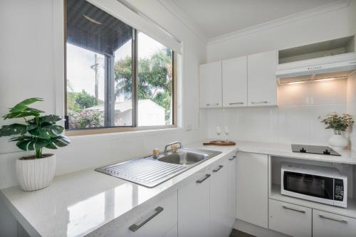a white kitchen with a sink and a window at Tasman Holiday Parks - Hervey Bay in Hervey Bay