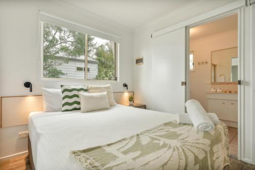 a bedroom with a large white bed with a window at Tasman Holiday Parks - Hervey Bay in Hervey Bay