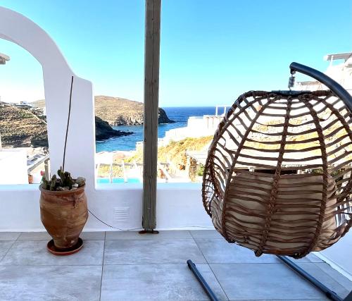 un panier en osier et un vase assis sur une terrasse dans l'établissement Miramare Suites Mykonos, à Merchia Beach