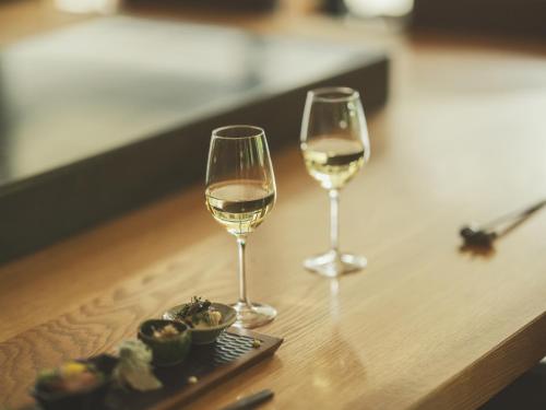 two glasses of white wine sitting on a table at SOKI ATAMI in Atami