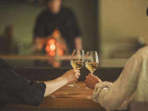 two people are holding glasses of white wine at SOKI ATAMI in Atami