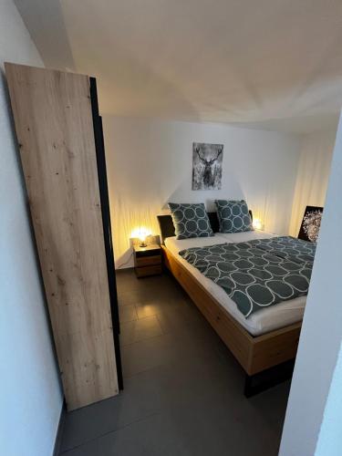 Schlafzimmer mit einem Bett und einer Holztür in der Unterkunft Schönes Apartment mit Terrasse in Waldstetten