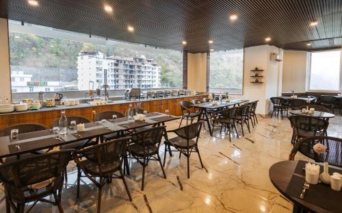 un restaurante con mesas y sillas y un bar en Stone Wood Hotel, Rishikesh, en Rishīkesh