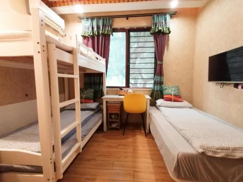 a room with two bunk beds and a desk at Hangzhou Citynest Music B&B in Hangzhou