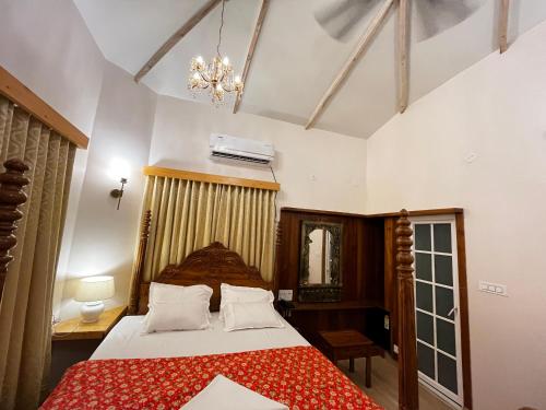 ein Schlafzimmer mit einem großen Bett mit einer roten Decke in der Unterkunft Dip Holidays in Shānti Niketan
