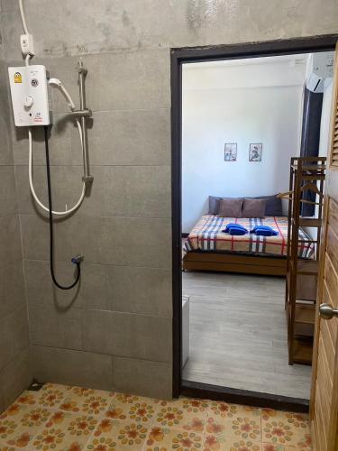 a bathroom with a shower and a bed in a room at Colibri Inn in Thong Sala