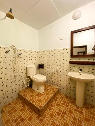 a bathroom with a toilet and a sink at Surfers Park Arugambay in Arugam Bay