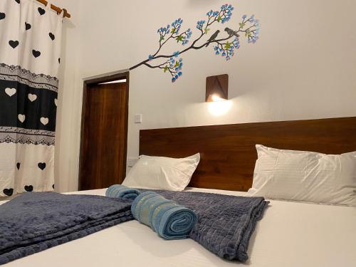 a bedroom with a bed with a blue blanket on it at Surfers Park Arugambay in Arugam Bay