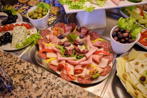 a table with plates of food on a buffet at Hotel Regal in Braşov