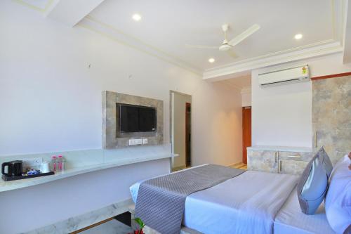 a bedroom with a bed and a tv on a wall at Trim Boutique Parkota Haveli in Jaipur