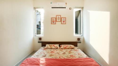 een kleine slaapkamer met een bed en 2 ramen bij Aum Villa Pet Friendly in Karjat