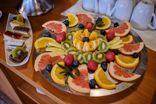 a plate of fruit on a wooden table at Hotel Regal in Braşov