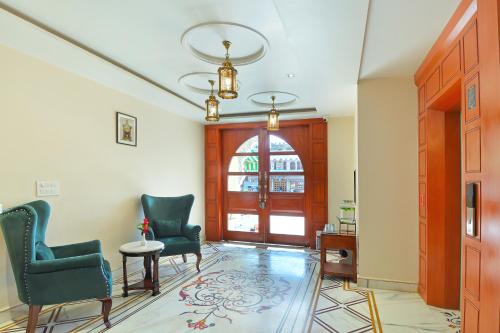 a living room with two chairs and a door at Trim Boutique Parkota Haveli in Jaipur
