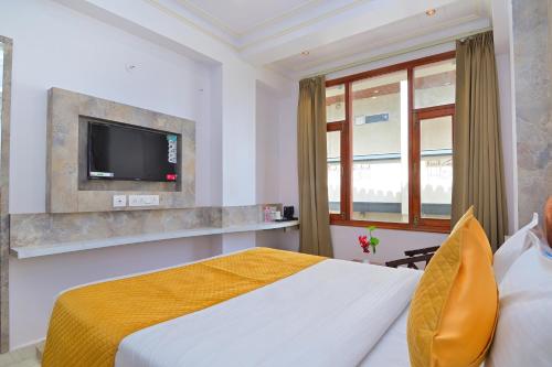 um quarto de hotel com uma cama e uma televisão de ecrã plano em Trim Boutique Parkota Haveli em Jaipur