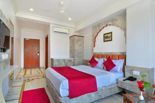 a bedroom with a large bed with a red blanket at Trim Boutique Parkota Haveli in Jaipur
