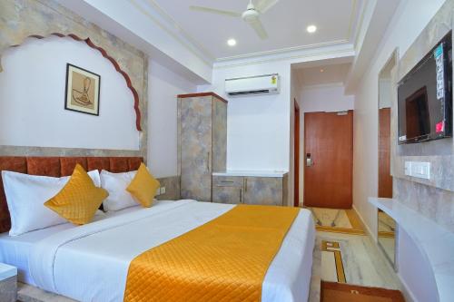a hotel room with a bed and a tv at Trim Boutique Parkota Haveli in Jaipur