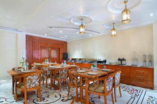 uma sala de jantar com mesas de madeira e uma cozinha em Trim Boutique Parkota Haveli em Jaipur