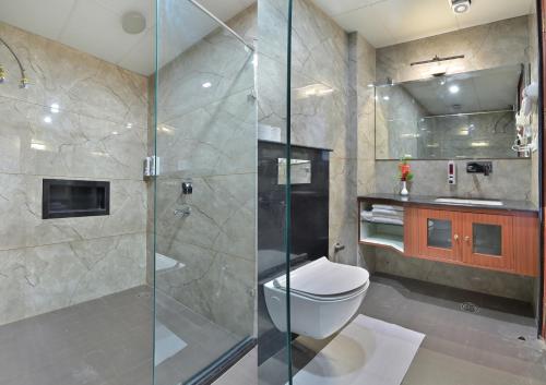 a bathroom with a toilet and a glass shower at Trim Boutique Parkota Haveli in Jaipur